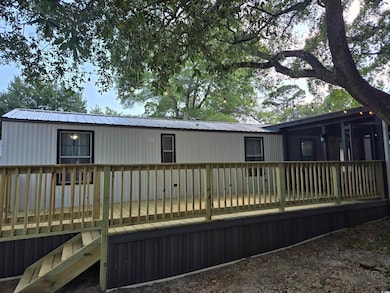 Back of house featuring a wooden deck and metal roof
