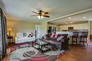 Spacious great room,  with laminate flooring & ceiling fan, opens to kitchen & dining area.