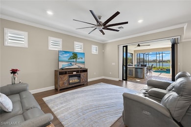Living room with ceiling fan, a fireplace, dark wo
