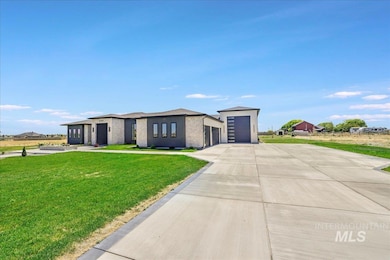View of front of home featuring a front lawn, concrete driveway, and an attached garage