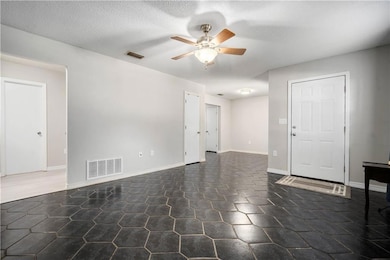 Unfurnished room featuring a ceiling fan and a textured ceiling