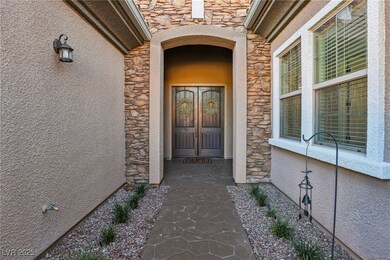 View of exterior entry with stone siding and stucc