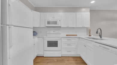 Kitchen featuring white appliances, a sink, white 