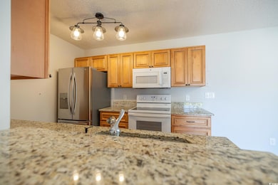 Kitchen with a textured ceiling, lofted ceiling, l