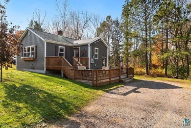 Back of house featuring a deck and a lawn