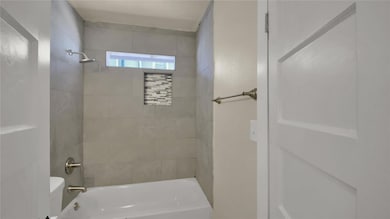 Bathroom featuring bathtub / shower combination and toilet