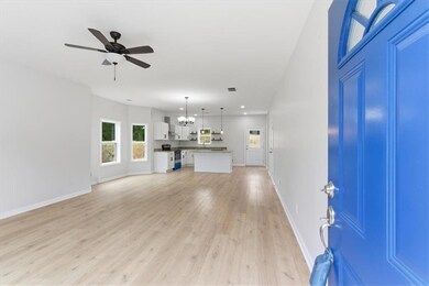 Unfurnished living room with light wood finished floors, a chandelier, ceiling fan, and recessed lighting