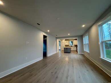 Unfurnished living room featuring recessed lighting and dark wood-type flooring