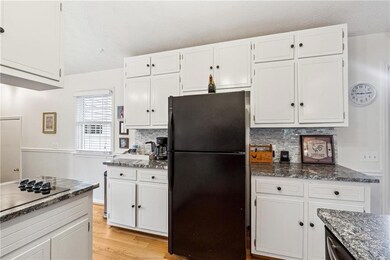 Kitchen featuring white cabinets, backsplash, and 