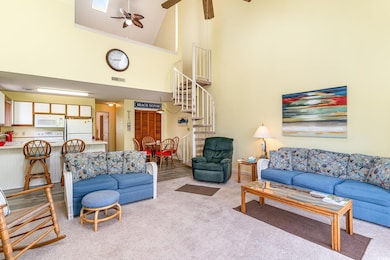 Living room with ceiling fan, light colored carpet, stairway, a high ceiling, and crown molding