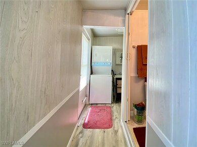 Corridor featuring stacked washer and dryer
and l