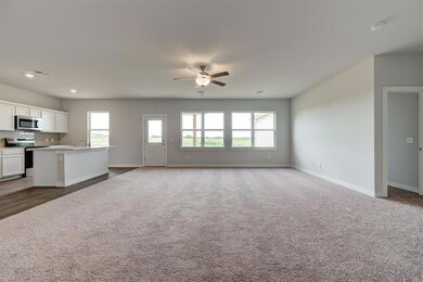 Unfurnished living room featuring healthy amount of natural light, a sink, light colored carpet, a ceiling fan, and recessed lighting