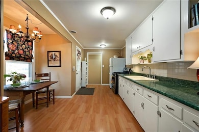 Open kitchen with white cabinetry, and ample storage.
