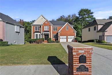 View of front of house featuring a front yard, concrete driveway, and a garage