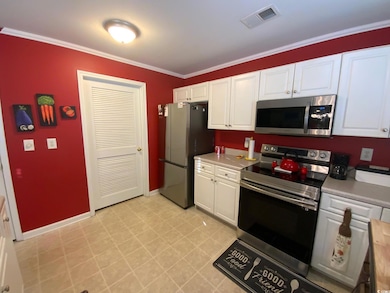 Kitchen featuring white cabinets, ornamental moldi