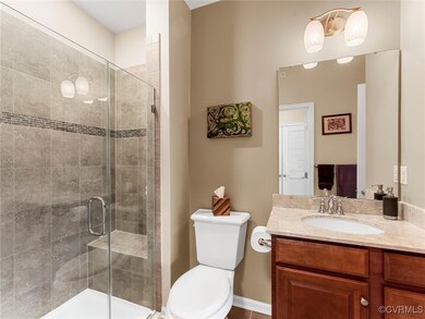 Bathroom with vanity, a shower stall, and toilet
