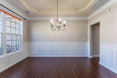 Lovely dining room has tray ceiling & detailed moldings.