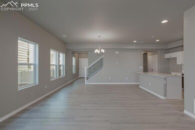 Unfurnished living room featuring baseboards, stai