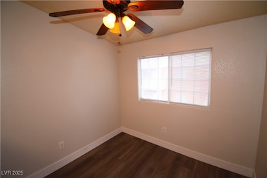 Unfurnished room with dark wood-style floors and ceiling fan