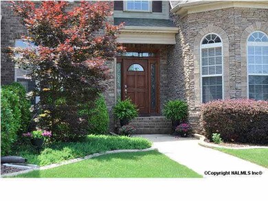 Greet family and friends at your gorgeous front entry with mature landscaping and stone accents.