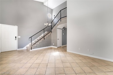 Foyer with a high ceiling, light tile patterned fl