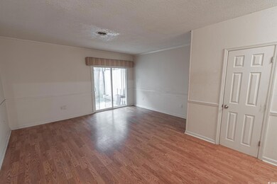 Empty room featuring crown molding, wood-type floo