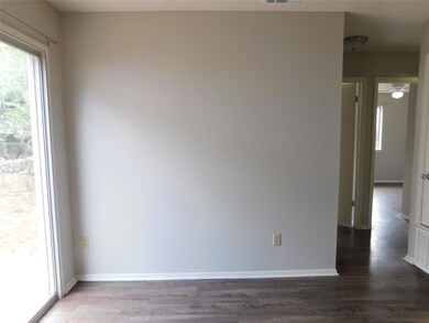 Empty room with dark wood-type flooring and baseboards