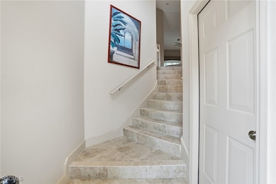 Stairs with tile patterned flooring and a ceiling fan