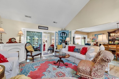 Living room with high vaulted ceiling, light hardw