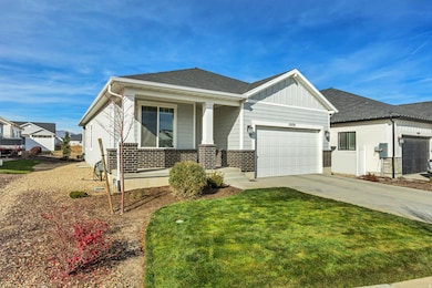 View of front of house with board and batten siding, a porch, concrete driveway, brick siding, and a front yard