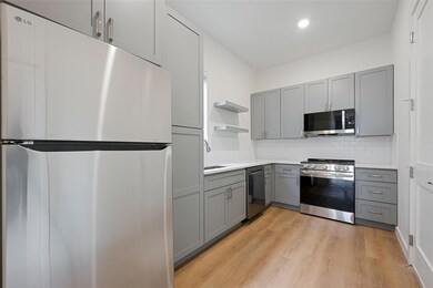 Kitchen with light wood finished floors, appliance