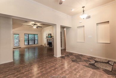 View of the living room from the formal dining.  Fireplace has a gas starter. Windows overlook backyard