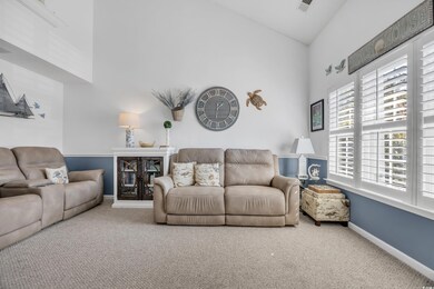 Living room featuring carpet floors, high vaulted 