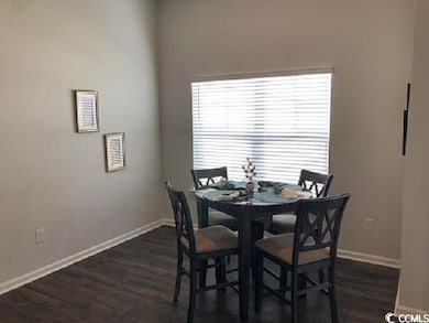 Dining space with baseboards and dark wood-style f