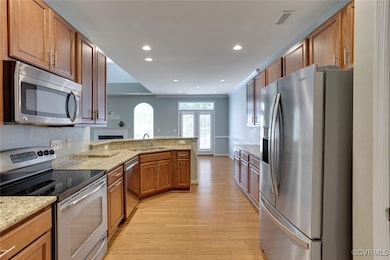Kitchen with stainless steel appliances, light woo