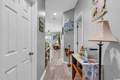 Hall with baseboards, wood finished floors, and re