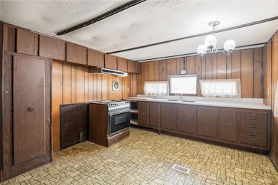 Kitchen with range with electric stovetop, under c