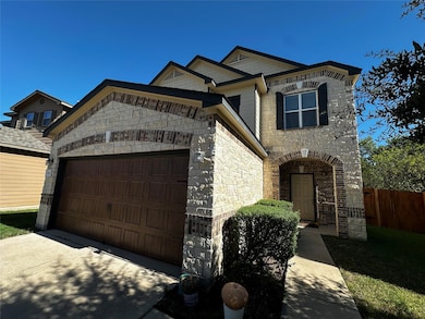 View of front of home featuring concrete driveway, stone siding, and a garage