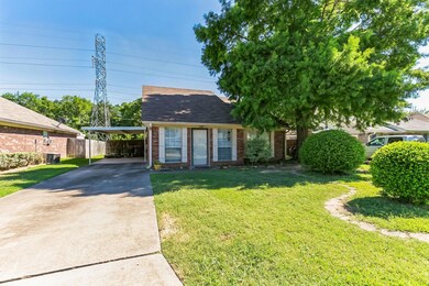 View of front facade with a carport and a front ya