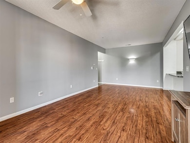 Spare room with a textured ceiling, a ceiling fan, and dark wood finished floors