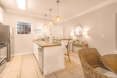 Kitchen with a peninsula, a breakfast bar area, ornamental molding, and stainless steel appliances