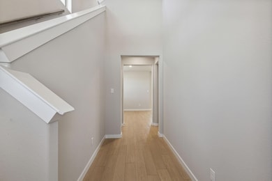 Corridor featuring light wood-style flooring, bas