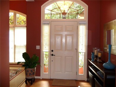 Entrance foyer with plenty of natural light, light wood finished floors, and a chandelier