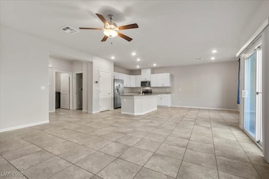 Kitchen featuring open floor plan, white cabinetry, an island with sink, a ceiling fan, and recessed lighting