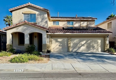 View of front of house with roof mounted solar panels, concrete driveway, stucco siding, and a tile roof