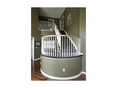 Entry features a dramatic curving staircase.