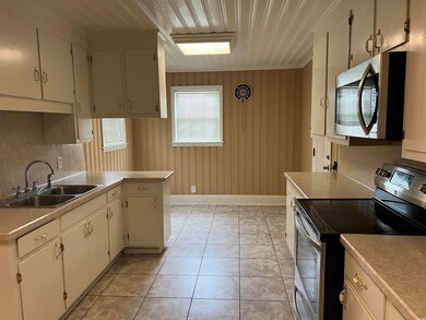 Kitchen with white cabinetry, tasteful backsplash,