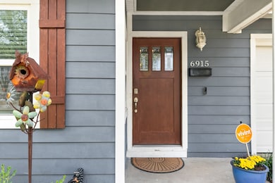 Charming curb appeal featuring blue fiber cement siding, rich wood shutters, and a cozy front porch welcome.
