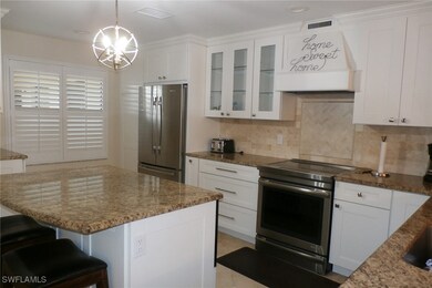 Kitchen with white cabinetry, tasteful backsplash,