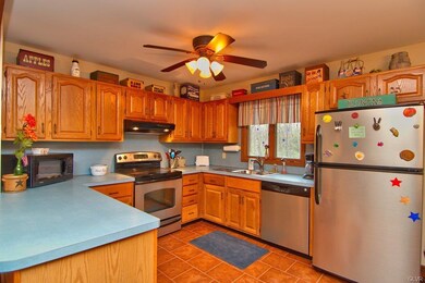 The kitchen features hardwood cabinetry, a tile fl